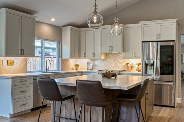 Alston Kitchen – Featuring Cabinetry by Durasupreme with a Knotty Cherry Island, AKDO herringbone backsplash. Countertops of CeaserStone in a suede finish.