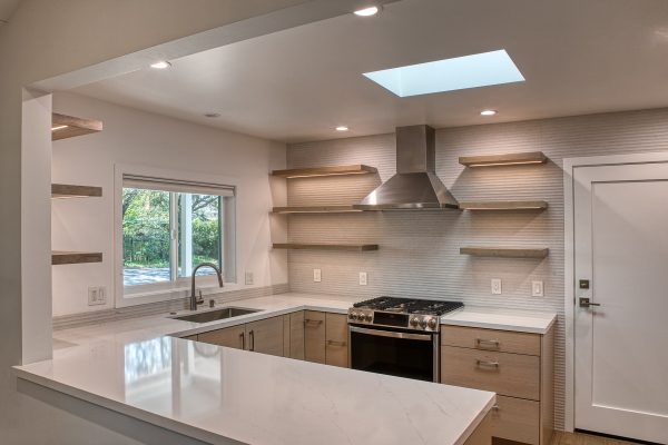 Modern Texture Kitchen – Featuring cabinetry by Bellmont 1600 in Dune rift cut horizontal, Hardware by Top Knobs in a Brush Nickel slim pulls. Large Porcelanosa tile adds texture to the walls.